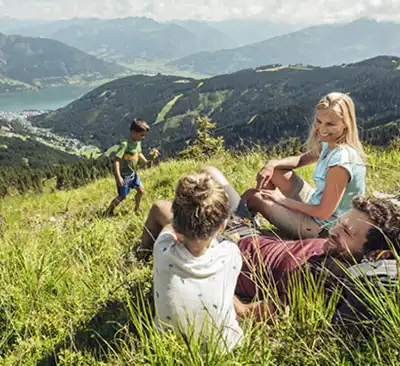 Familie beim Genießen auf dem Berg in Zell am See in Österreich.