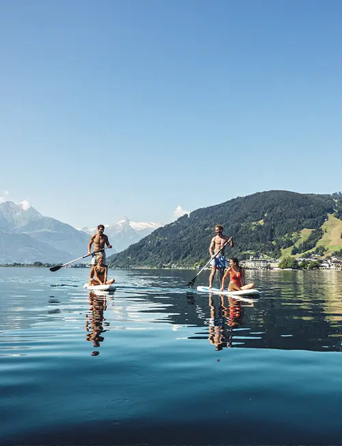 Zwei Paare beim Wassersport Stand-up-Paddling in Zell am See in Österreich.